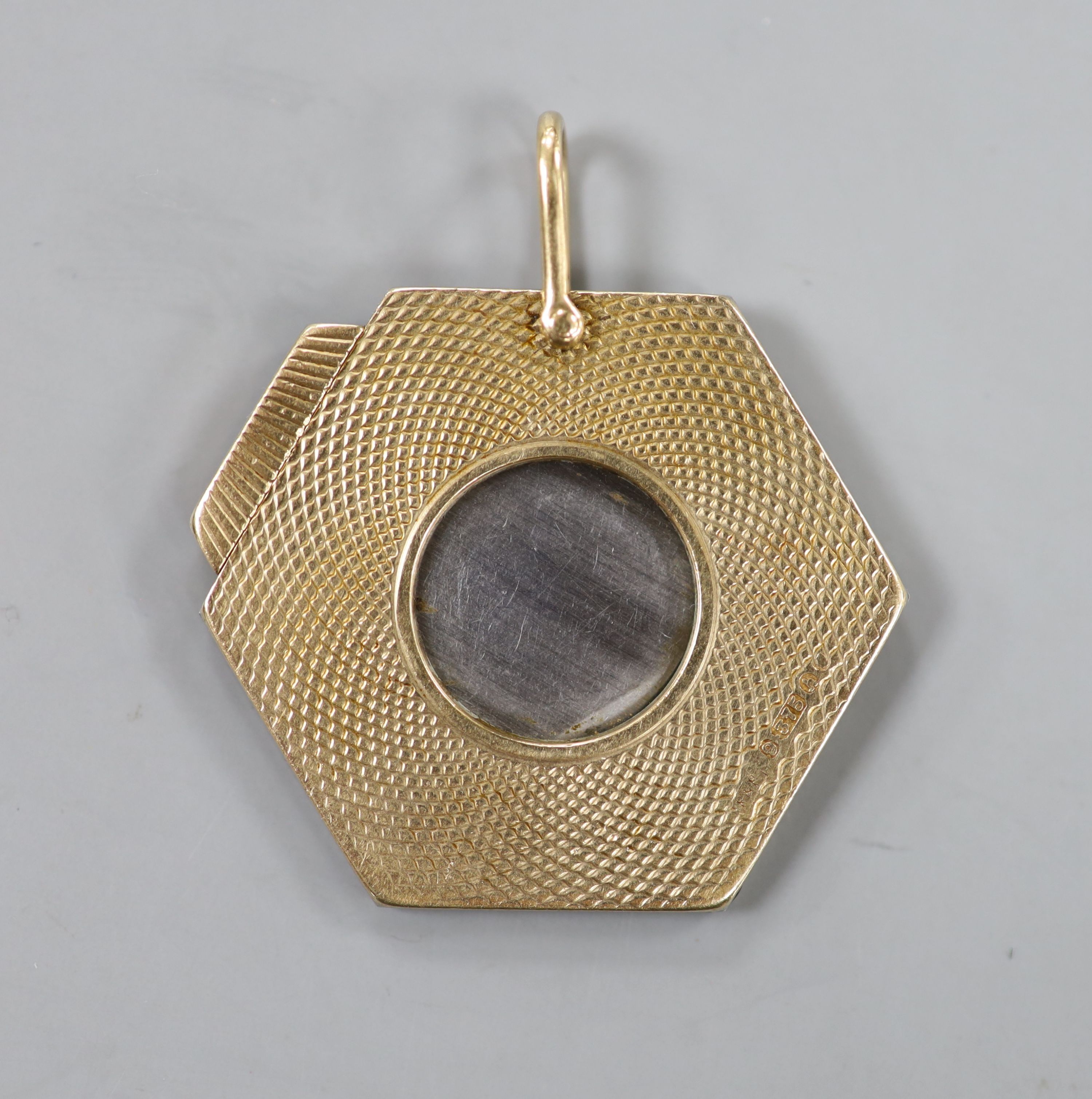 A 1960's engine turned 9ct gold hexagonal cigar cutter, 34mm.